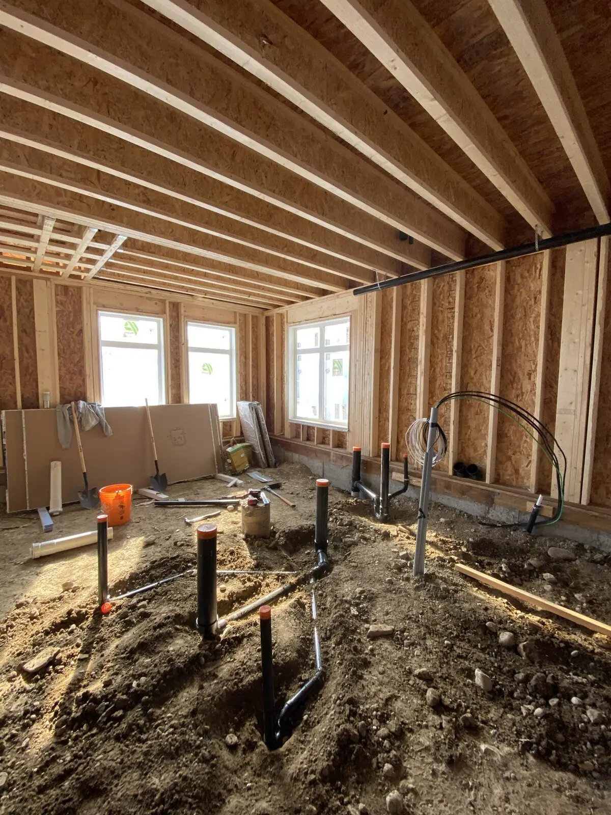 Plumbing rough-in inside a wood-framed multi-family building